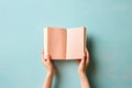 Hands holding an open book on pastel background. Reading, studying, school, diary, education, university learning, time for Royalty Free Stock Photo