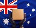 Hands holding a package against the background of the Australian flag Royalty Free Stock Photo