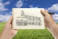 Hands Holding Paper With House Drawing Over Empty Grass Field Royalty Free Stock Photo