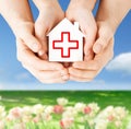 Hands holding paper house with red cross Royalty Free Stock Photo