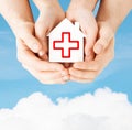 Hands holding paper house with red cross Royalty Free Stock Photo