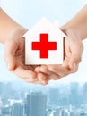 Hands holding paper house with red cross Royalty Free Stock Photo