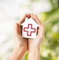 Hands holding paper house with red cross Royalty Free Stock Photo