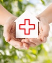 Hands holding paper house with red cross Royalty Free Stock Photo