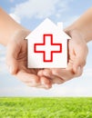Hands holding paper house with red cross Royalty Free Stock Photo