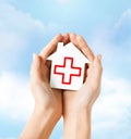 Hands holding paper house with red cross Royalty Free Stock Photo