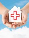 Hands holding paper house with red cross Royalty Free Stock Photo