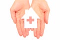 Hands holding paper house with red cross sign