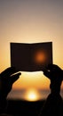 Hands holding paper at sunset eclipse Royalty Free Stock Photo