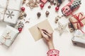 hands holding pencil and writing a letter wish list to santa claus flat lay with space for text. merry christmas and happy new ye Royalty Free Stock Photo
