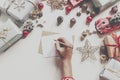 hands holding pencil and writing a letter wish list to santa claus with space for text. merry christmas and happy new year. child Royalty Free Stock Photo