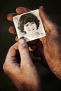 Hands, holding picture of kid and portrait, nostalgia or remember memory of family or child on black background