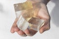 Hands holding piece of Optical Calcite