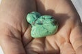 Hands holding piece of turquoise