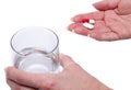 Hands holding pills and a glass of water Royalty Free Stock Photo