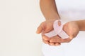 Hands holding pink ribbon curl on white isolated fabric with copy space. Breast cancer Awareness, male breast cancer disease, Royalty Free Stock Photo