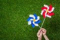 Hands holding pinwheels over grass