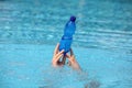 hands holding plastic bottle of water above surface of water