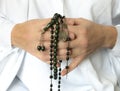 Hands holding prayer beads