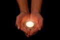 Hands holding and protecting lit or burning candle candlelight on darkness. Royalty Free Stock Photo