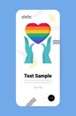 hands holding rainbow heart gay lesbian LGBT parade pride festival transgender love concept vertical Royalty Free Stock Photo