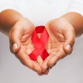 Hands holding red AIDS awareness ribbon Royalty Free Stock Photo