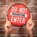 Hands holding red do not enter fraudsters sign Royalty Free Stock Photo