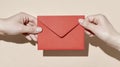 Hands holding a red envelope on neutral background - minimalistic communication concept Royalty Free Stock Photo