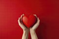 Hands Holding a Red Heart on a Red Background. Valentine's Day, Birthday, Mother's Day