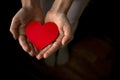 Hands holding red heart on black background. Health insurance, organ donor day, charity concept. World health, mental Royalty Free Stock Photo