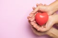 Hands holding a red heart on pink background, CSR or Corporate Social Responsibility, health care Royalty Free Stock Photo