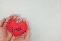 Hands holding a red heart tag with handwritten word local. Support, promote, buy, shop and love local business concept.