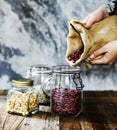 Hands holding sack and pouring beans to the glass jar