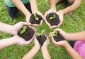 Hands holding sapling in soil surface