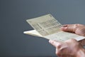 Hands holding saving account passbook, book dark on gray background