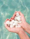 Hands holding sea salt crystals heart-saped on sea water background