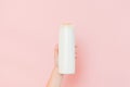 Hands holding shampoo, hair conditioner or body lotion bottle in pink background. Cosmetics bottle Royalty Free Stock Photo