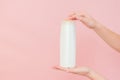 Hands holding shampoo, hair conditioner or body lotion bottle in pink background. Cosmetics bottle Royalty Free Stock Photo