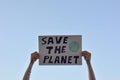 Hands holding a sign with blue sky in the background to fight climate change. Concept of global warming and environment Royalty Free Stock Photo