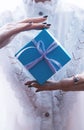 Hands holding a small gift wrapped with pink ribbon. Small gift in the hands of a woman indoor Royalty Free Stock Photo