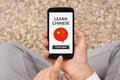 Hands holding smart phone with learn Chinese concept on screen Royalty Free Stock Photo