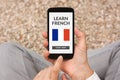 Hands holding smart phone with learn French concept on screen Royalty Free Stock Photo