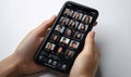 Hands holding smartphone displaying video conference grid of people Royalty Free Stock Photo