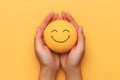 Hands Holding Smiley Face Stress Ball Yellow Background Royalty Free Stock Photo