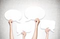 Hands holding speech bubbles, concrete wall Royalty Free Stock Photo