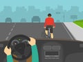 Hands holding a steering wheel. Driver overtaking a cyclist on highway. Back view of cycling bike rider.