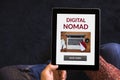 Hands holding tablet with digital nomad concept on screen Royalty Free Stock Photo