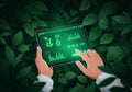 Hands holding a tablet displaying a green digital interface surrounded by lush foliage representing sustainable technology Royalty Free Stock Photo