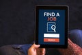 Hands holding tablet with find a job concept on screen