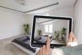 Hands holding tablet showing plans in finished room. Modern apartment. Technical drawing. Home Interior Design Software Royalty Free Stock Photo